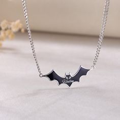 Necklace Details 📿 ------------------------------------------------------ Feature:  Embrace the spookiness of Halloween with our enchanting Custom Black Bat Name Necklace.  Crafted with precision and care, the necklace features a charming black bat pendant made of stainless steel and adorned with enamel work. The combination of stainless steel and enamel gives the pendant a durable yet stylish look. The bat is intricately designed, with fine details that make it truly stand out. It can be enjoyed for many Halloweens to come. What makes this necklace truly special is the custom name option. Personalize it with your own name, a loved one's name, or a special word that holds meaning for you. It's a one-of-a-kind piece that is sure to become a treasured keepsake. Whether you're looking for a Vampire Style Necklaces For Halloween Cosplay, Silver Necklaces For Halloween Cosplay, Silver Necklace For Halloween Cosplay, Vampire Style Necklace For Halloween, Black Themed Necklace For Halloween, Halloween Themed Black Necklace, Themed Jewelry For Halloween Cosplay, Themed Black Necklace For Halloween, Black Spooky Jewelry For Costume Party