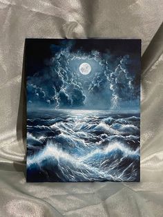 a painting on a white sheet that has waves in the water and a full moon above it