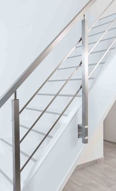 a white stair case with stainless steel handrails