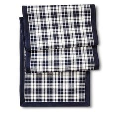 the navy and white checkered pocket square is folded on top of an unmade piece of cloth