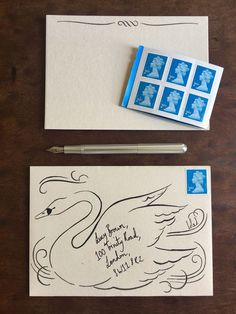 some stamps are laying on top of an envelope and next to it is a swan stamp