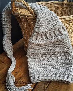 a white crocheted bag sitting on top of a wooden table next to a wicker basket