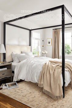 a four poster bed in a bedroom with white walls and beige carpeted flooring