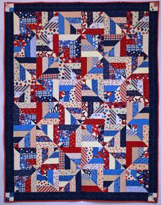 a red, white and blue quilt hanging on a wall