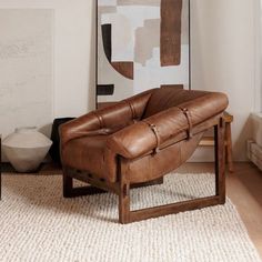 a brown leather chair sitting on top of a white rug