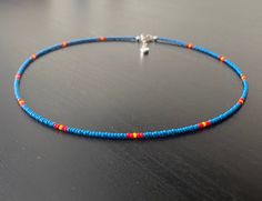 This necklace is made with Czech glass seed beads size 11/0in a mid tone, blue colour. Accent colours in red and yellow. The necklace comes with a 1 inch silver extender chain. Blue Choker With Tiny Round Beads, Blue Choker With Tiny Beads, Blue Single Strand Choker With Round Beads, Seed Bead Color Combinations, Blue Seed Bead Necklace, Hip Jewelry, Mens Beaded Necklaces, Red Beaded Necklaces, Beaded Necklace Patterns