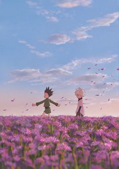 two people walking through a field of purple flowers