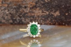 ✨ Embrace Timeless Elegance with Our Princess Diana Inspired Halo Engagement Ring ✨ Step into a world of romance and sophistication with this stunning halo engagement ring, inspired by the iconic style of Princess Diana. Featuring a mesmerizing 1-carat emerald gemstone at its center, this ring beautifully captures the essence of classic elegance and modern luxury. 🌿 Key Features: Main Stone: Name: Green Emerald (Natural 6x8 mm) Weight: Approximately 1 ct. Color: Vibrant Green Shape: Oval Certif