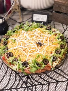 a pizza sitting on top of a table covered in cheese and olives