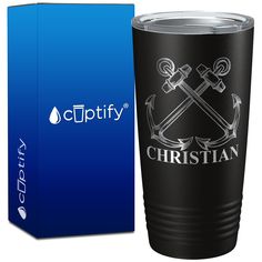 a black cup with an anchor and cross on it in front of a blue box