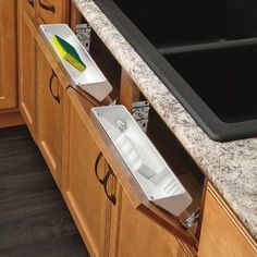 a kitchen counter with two sinks and an empty dishwasher in the drawer next to it