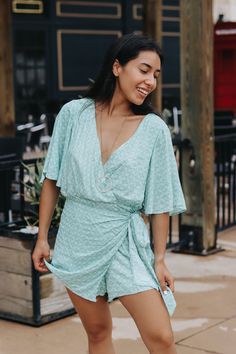 Short sleeve V-neck, wrap bottom romper. Rebeka is wearing a size smallLightweight Lined﻿Size Chart:Small: Waist: 26 in. Hips: 38 in.Medium: Waist: 28 in. Hips: 40 in. Large: Waist: 30 in. Hips: 42 in.HEY BABE! WE ONLY OFFER STORE CREDIT FOR RETURNS! Feel free to email us or DM us on Instagram with any questions regarding fit or sizing or our return policy in general. Summer V-neck Wrap Dress For Brunch, Chic Spring Jumpsuits And Rompers With Surplice Neckline, Vacation V-neck Wrap Dress With Tie Waist, Vacation Wrap Dress With Tie Waist And V-neck, Chic Jumpsuit With Surplice Neckline For Spring, V-neck Wrap Dress With Tie Waist For Day Out, V-neck Wrap Dress With Tie Waist For Vacation, Chic Spring Jumpsuits With Surplice Neckline, Summer Vacation Jumpsuits And Rompers With Surplice Neckline