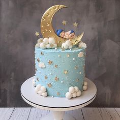 a baby is sleeping on top of a blue cake with stars and moon decors