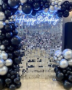 black and silver balloons are in front of a mirror wall with the words happy birthday on it