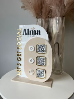 an alarm clock sitting on top of a table next to a vase with feathers in it