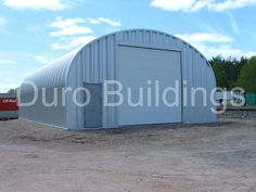 a large metal building sitting on top of a dirt field