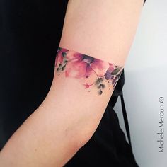 a woman's arm with watercolor flowers on it