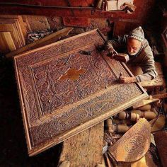 an old man is working on a large wooden box