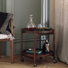 a small table with two glasses on it next to a chair