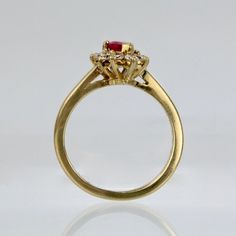 A wonderful cocktail ring by Kurt Wayne.  In 18K yellow gold with a half-twist to the shank. The shank supports a gallery with a central pear-cut ruby and 10 small round cut diamonds.   A high-level ring from the famous New York jewelry designer!  Marked to the shank 750 for 18k gold fineness and with a conjoined KW for Kurt Wayne.  Ring Size: ca. 5 1/2  Dimensions reference the ring size and are not specific to the ring itself. Fine Jewelry Yellow Gold Ruby Ring With Halo Setting, Heirloom Yellow Gold Ruby Ring With Halo Design, Heirloom Ruby Ring In Yellow Gold With Halo Design, Fine Jewelry Yellow Gold Ruby Ring With Halo Design, Gold Marquise Ruby Ring With Diamonds, Yellow Gold Ruby Ring With Diamond Halo Setting, Gold Ruby Ring Pear-shaped, Yellow Gold Ruby Ring With Halo Diamond Setting, Gold Ruby Cluster Ring With Halo Setting