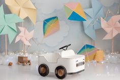 a toy car is sitting in front of some paper umbrellas