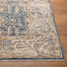 a blue and yellow area rug on a wooden floor with a wood floor in the background