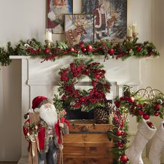 a christmas mantel decorated with red and green wreaths, pine cones, holly berries, santa claus's stockings and other holiday decorations