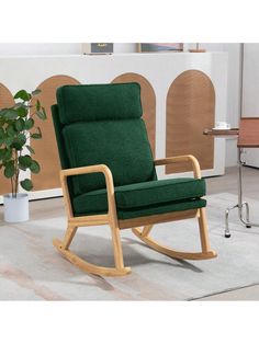 a green rocking chair sitting on top of a carpeted floor next to a potted plant