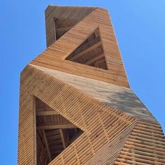 a tall wooden structure with many windows on it's sides and a blue sky in the background