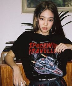 a woman in a space shuttle t - shirt holding a mouse