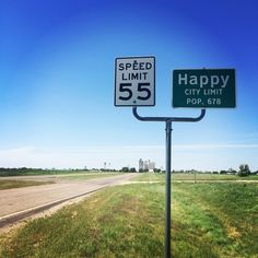 the speed limit sign is on the side of the road in front of an empty highway