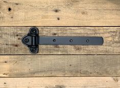 a close up of a metal latch on a wooden door with wood planks in the background