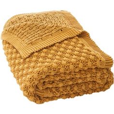 a yellow knitted blanket folded on top of each other in front of a white background