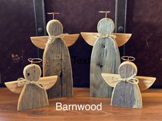 three wooden angel figurines sitting next to each other