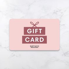 a pink gift card sitting on top of a white marble surface with the words, gift card