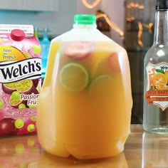 a pitcher of liquid sitting on top of a table next to two bags of fruit juice