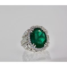 This is part of Chairish’s Fine Jewelry assortment.  Oval Emerald 12.25 Carat Diamond Surround 8.85 Carat Total Weight 21.10 Carat  This oval Emerald weights in at 12.25 carats and is a gorgeous Emerald Green with transparency. The Diamonds weigh in at 8.85 Carats and the mount is exceptional the Diamonds are VS1-VS2 and G-J in color. This is a bombe mount. The shoulders of the ring are embellished with baguette cut Diamonds in the center border with a perimeter of round cut Diamonds accents. Th Luxury Oval Emerald Birthstone Ring, Luxury Emerald Ring With Diamond, Luxury Marquise Emerald Ring, Luxury Marquise Emerald Ring With Diamonds, Luxury Green Diamond Ring For Formal Occasions, Luxury Halo Ring With Round Cut Gemstone, Luxury Platinum Halo Ring With Gemstone, Luxury Oval Diamond Ring, Luxury Marquise Emerald Ring With Prong Setting