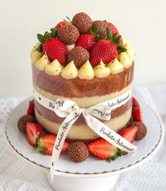 a cake on a plate with strawberries and other food items around the top layer