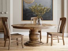 a dining room table and chairs with a chalkboard in the background