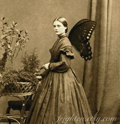 an old photo of a woman with a butterfly on her head, holding a fan