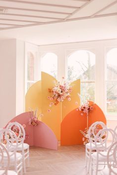 an empty room with chairs and flowers on display