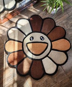 a flower shaped rug on the floor in front of a potted plant