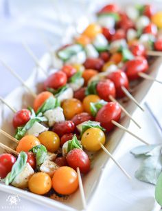 several small skewers filled with tomatoes and cheese