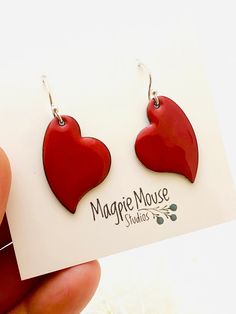 Heart Earrings ~ Red Enamel Minimalist Asymmetrical Heart Drop Earrings A perfect gift for the one you love! And if that's you, that's great!! Red enamel heart measures 1 inch in height. Copper heart with fused enamel. Made with Sterling silver earwires. Handle as glass. Handmade in the Pacific Northwest ❤️ Heart Charm Enamel Earrings, Heart-shaped Enamel Earrings With Charm, Handmade Heart-shaped Enamel Earrings, Enamel Heart Charm Earrings As Gift, Enamel Earrings With Heart Charm As Gift, Valentine's Day Heart Charm Enamel Earrings, Handmade Red Heart Earrings In Sterling Silver, Handmade Red Heart Sterling Silver Earrings, Red Dangle Earrings For Everyday