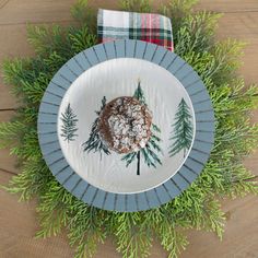 a white plate topped with a pastry covered in powdered sugar next to green plants