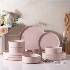 the table is set with pink dishes and silverware