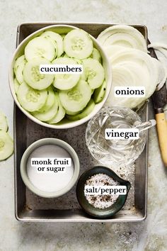 cucumbers, onions, and other ingredients are arranged in bowls on a tray