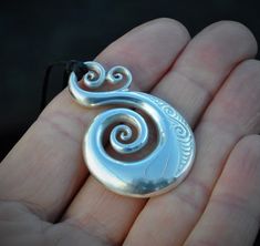 Hand crafted New Zealand Maori koru design in Solid 925 Sterling silver. A sculptural piece that is fully shaped on the front & the back. It has a smooth highly polished finish and engraved Maori design. It measures 1.7 inches long or 4.3cm and 1.1 inch wide. The Maori koru is a treasured symbol in New Zealand, it represents nature and symbolises new beginnings & spiritual growth bringing renewal & inspiring new ideas & adventures. The fine koru detail on the top symbolises love Unique Spiral Sterling Silver Necklace, Spiral Shaped Sterling Silver Jewelry, Sterling Silver Swirl Jewelry, Sterling Silver Swirl Jewelry In Silver, Sterling Silver Necklace With Carved Round Pendant, Carved White Gold Sterling Silver Jewelry, Unique Spiral Sterling Silver Jewelry, Sterling Silver Swirl Necklaces, Sterling Silver Swirl Jewelry Gift