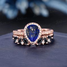 a blue and white diamond ring set on top of a table