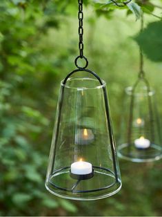 two hanging glass lanterns with candles in them